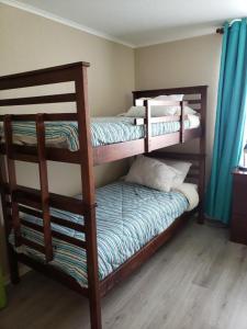 阿尔加罗沃Laguna Bahía Fernanda的一间卧室配有两张双层床和蓝色窗帘