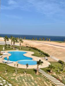 赫尔格达Soma Bay Apartment的海滩旁游泳池的顶部景色