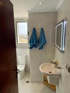 赫尔格达Soma Bay Apartment的浴室设有水槽和带蓝色毛巾的卫生间。