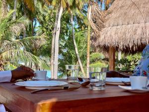 福拉杜岛Island Luxury Boutique Hotel - Fulhadhoo的木桌,带杯子,盘子和玻璃杯