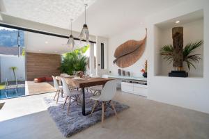 普吉镇Labriz Ocean Villa - Tropical Modern Living的厨房以及带桌椅的用餐室。
