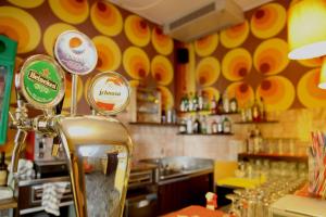 里米尼Sunflower City Student Hostel & Bar的餐厅设有酒吧,拥有黄色和橙色的墙壁