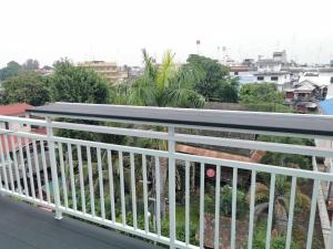 佛丕สีดา​ โฮสเทล的阳台设有白色栏杆,享有城市美景。