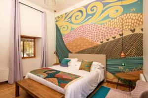 维库尼亚Solar Madariaga Hotel的一间卧室配有一张壁画床