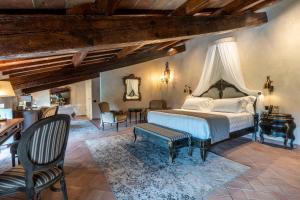切雷托圭迪Villa Petriolo的卧室配有一张床和一张桌子及椅子