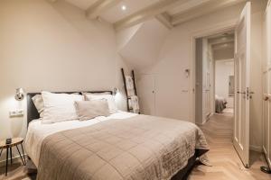 阿姆斯特丹Leidse Square 5 star Luxury Apartment的一间白色卧室,配有一张大床和一个走廊