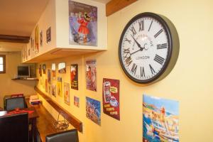Camurac卡姆拉克城堡酒店的墙上的时钟,上面有图片和海报