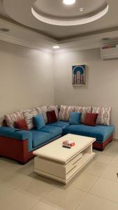Ar Ruqayyiqahشقق المربعة للشقق المخدومة的客厅配有蓝色的沙发和茶几