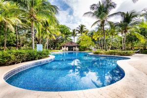 塔马林多Villa Estrella del Mar的一个带棕榈树和凉亭的游泳池