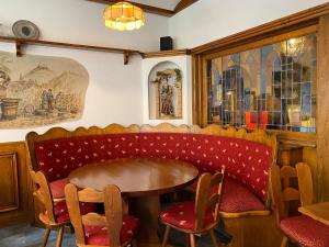 布赖斯高地区施陶芬兹姆赫尔斯恩酒店的餐厅设有红色长凳和桌椅