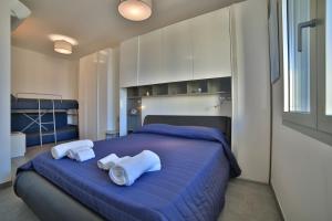 切萨雷奥港Residence il Caicco的一间卧室配有蓝色的床和毛巾