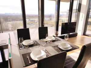 维也纳Panorama Apartment Vienna - free parking, sauna & fitness的一间带桌椅和窗户的用餐室