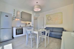 切萨雷奥港Residence il Caicco的厨房以及带桌椅的起居室。