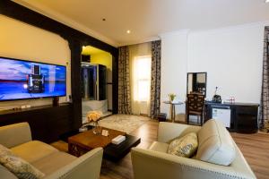 利雅德Millennia Olaya Hotel的带沙发和电视的客厅