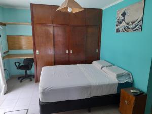 波萨达斯Casa cerca del microcentro y costanera的一间卧室配有一张床和一个木制橱柜
