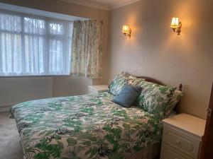 贝克斯利黑思Bexleyhealth Town Center 5 Bedroom Luxurious Home的一间卧室配有一张带鲜花毯子的床和窗户。