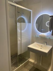 巴黎圣皮埃尔酒店的浴室配有盥洗盆和带镜子的淋浴