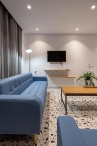 地拉那Spa & Pool - Studio Apartments 365的客厅配有蓝色的沙发和桌子