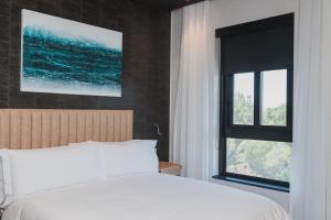 开普敦Century City Hotel Bridgewater的卧室配有白色的床和窗户。