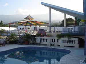 太子港Pavillon Des Receptions & Hotel的一个带庭院和遮阳伞的游泳池