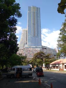 科伦坡Super Luxury 2 BR Apartment in Five Star Colombo City Centre的停在停车场的白色货车,有一座高大的建筑