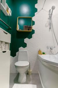里加Brassy apartment的一间带卫生间和绿色墙壁的浴室