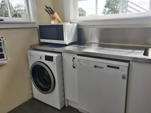 朗伊奥拉Bramley's Stables and Accommodation的厨房配有微波炉和洗衣机。