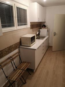 斯科普里White Night的厨房配有微波炉、椅子和冰箱