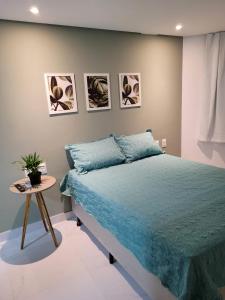 若昂佩索阿Espetacular Flat em Miramar 2的一间卧室配有一张蓝色的床和一张桌子