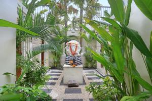 坎古The Wina Villa Canggu的庭院中种有植物的雕像