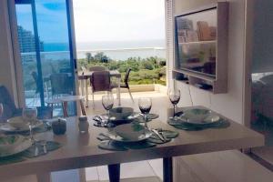 圣玛尔塔Pozos colorado Bello horizonte - Apartamento 70 mt2的一张桌子,上面有酒杯和盘子