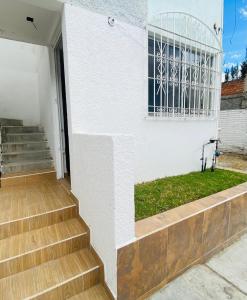 莱昂Cómodo y Pintoresco Depa Al sur de La Ciudad!的白色的房子,设有楼梯和窗户