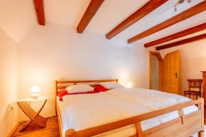 赖兴瑙Mühle in der Pferdewelt Reichenau的一间带一张床的卧室,位于带木制天花板的房间内