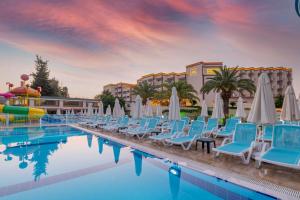 锡德Amara Family Resort的度假酒店的游泳池配有椅子和遮阳伞