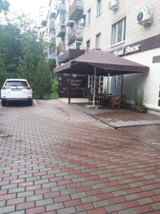 哈尔科夫Hotel Voyage的停在大楼前的带雨伞的停车场