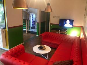杜塞尔多夫Backpackers Düsseldorf - SELF CHECK-IN的客厅配有红色的沙发和桌子