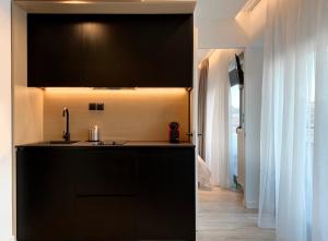 塞萨洛尼基ICON Urban Living的厨房配有黑色橱柜和水槽