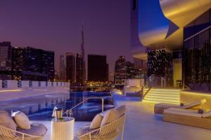 迪拜Hyde Hotel Dubai的一座城市天际线建筑屋顶上的游泳池