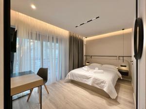 塞萨洛尼基ICON Urban Living的卧室配有白色的床、书桌和窗户。