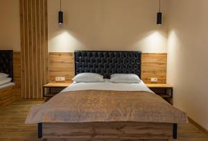 布克维Milana的一间卧室配有一张大床和木制床头板