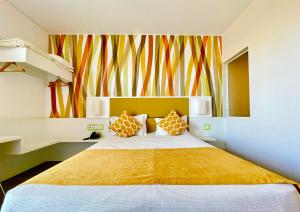 法鲁3K法鲁奥诺普特酒店的一间卧室设有一张大床和色彩缤纷的墙壁