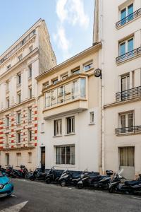 巴黎Edgar Suites Auteuil - Le Marois的停在大楼前的一排摩托车