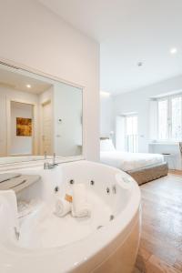 罗马Nikis Collection Trastevere的白色的浴室设有浴缸和大镜子