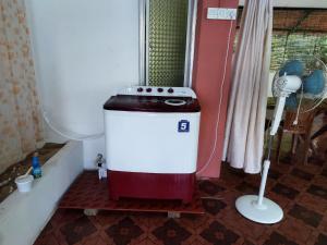 ShādipurThe Leisure Home Stay的一间带风扇的浴室内的洗衣机
