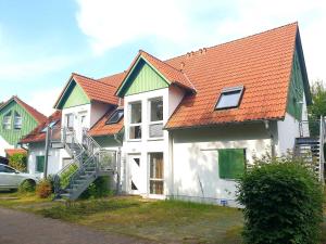 卡尔斯哈根Ferienwohnung Strandgold OLIV的一群有橙色屋顶和汽车的房屋