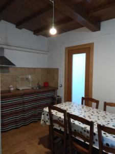 BeiresCasa Rural El Albergue的一间带桌子的用餐室和一间厨房