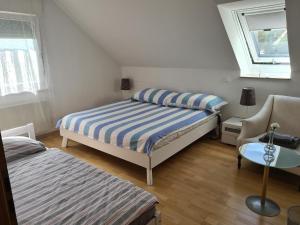 高莱茵河畔布辛根Appartement Paradiso的一间卧室设有两张床、一把椅子和一个窗户。