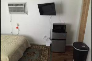 诺福克Cozy Mother-in-Law Suite的一间卧室配有一张床、一台微波炉和一台电视。