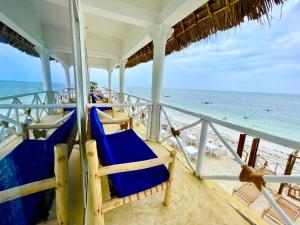 江比阿Equalia boutique hotel的海滨别墅,配有蓝色的椅子和海洋