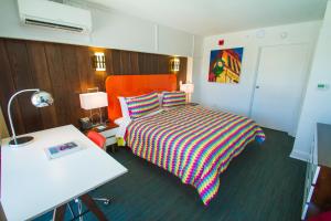 金斯顿Mother Earth Motor Lodge的酒店客房,配有一张带彩色毯子的床